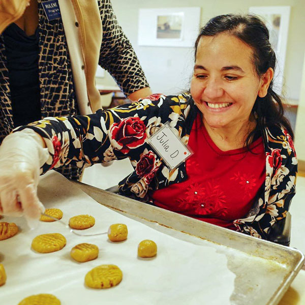 Julia helping make cookies at Grace Center during a baking activity 