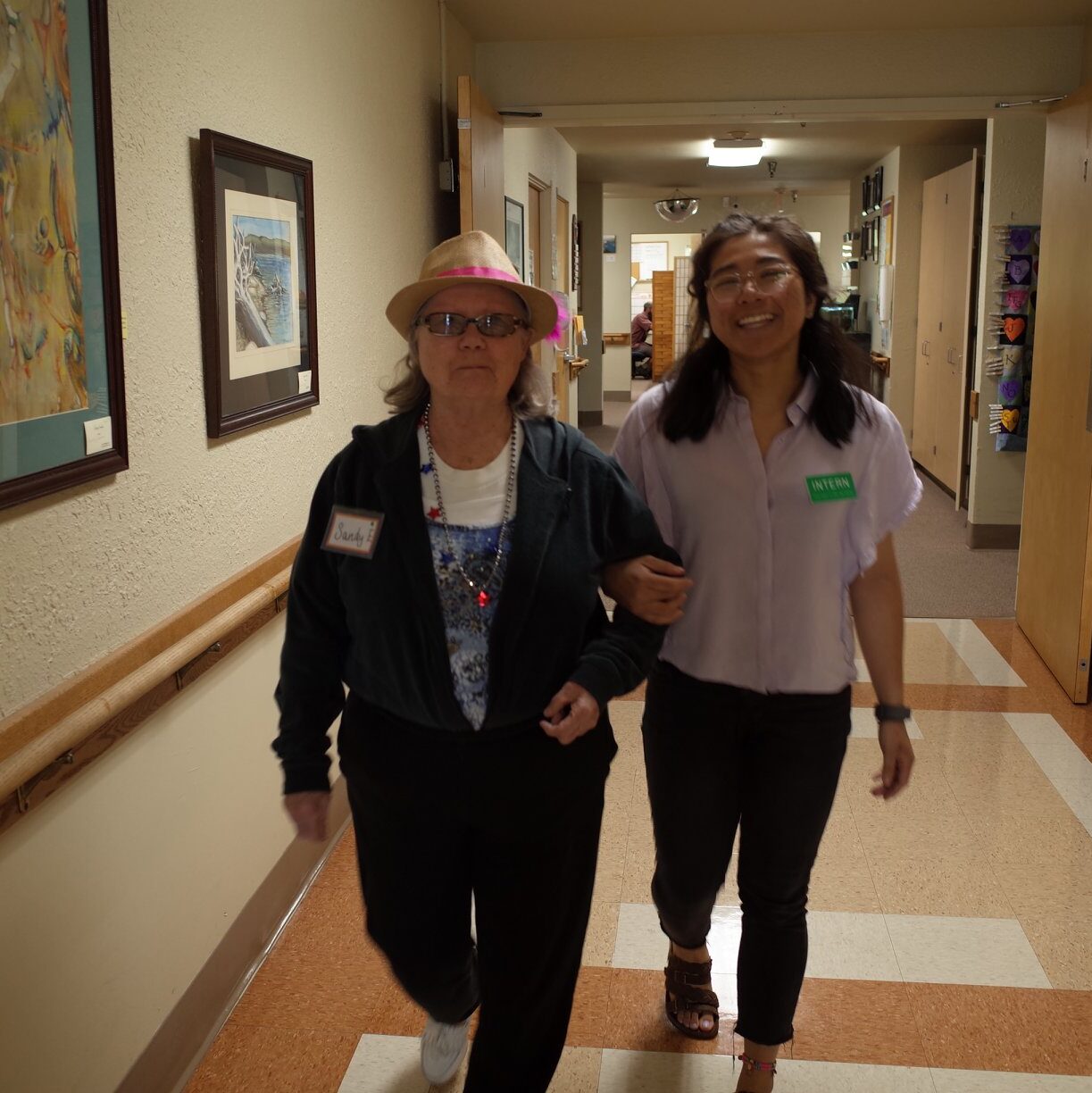 A Grace Center intern walking arm in arm with a participant